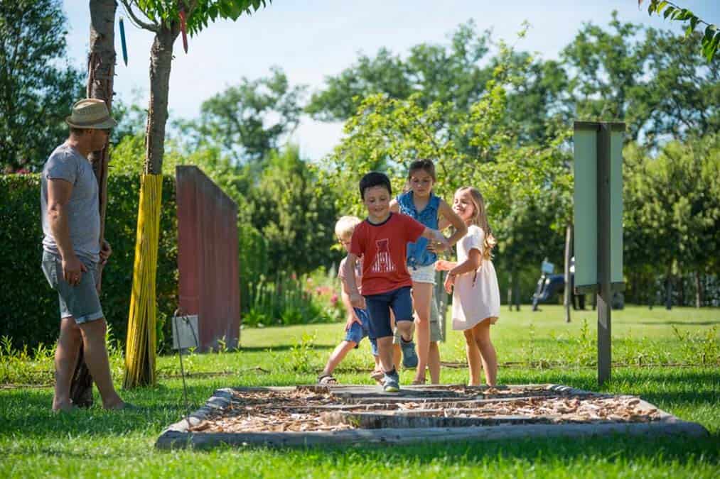 des enfants jouent à la marelle à tour de rôle aux Jardins de Colette