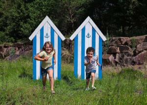 Deux enfants font la course devant des cabanes de plage