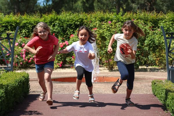 trois fillettes font la course dans les jardins de Colette