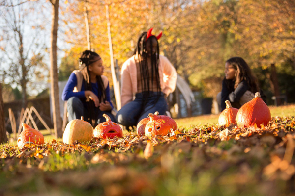 3 jeunes filles posent devant des citrouilles pour halloween aux Jardins de Colette