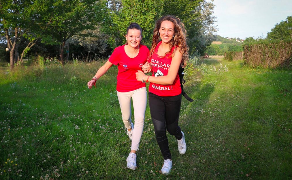 2 jeunes femmes avec des T-shirt rouge courent dans les jardins de Colette