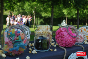 Gros plan sur des bonbon avec en arrière plan un groupe lors d'un événement aux Jardins de Colette