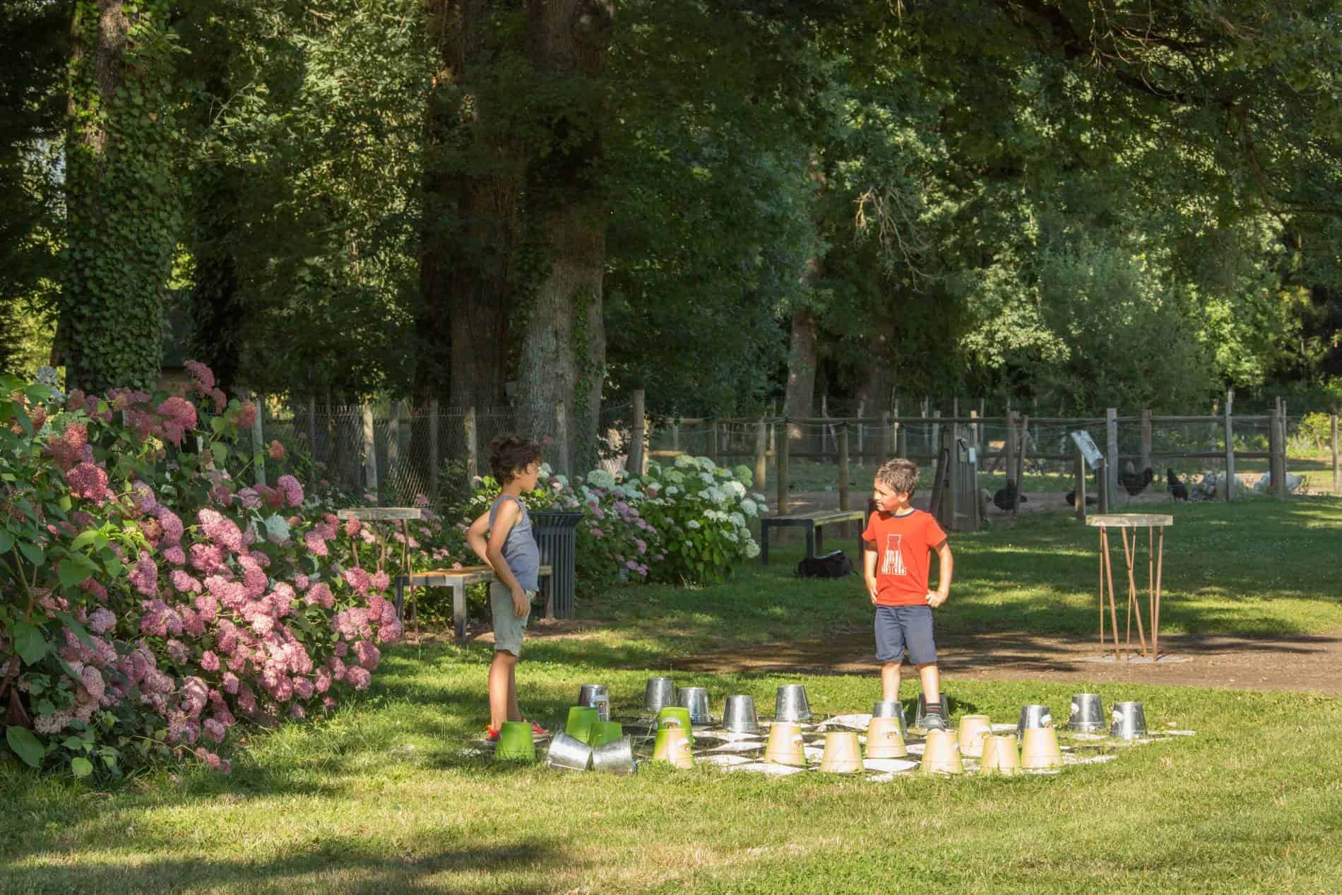 Enfants utilisant des jeux géants des Jardins de Colette en Corrèze.